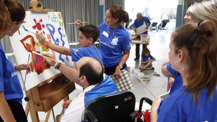 Voluntarios de Global Omnium participan en un taller de pintura junto a personas con  parálisis cerebral