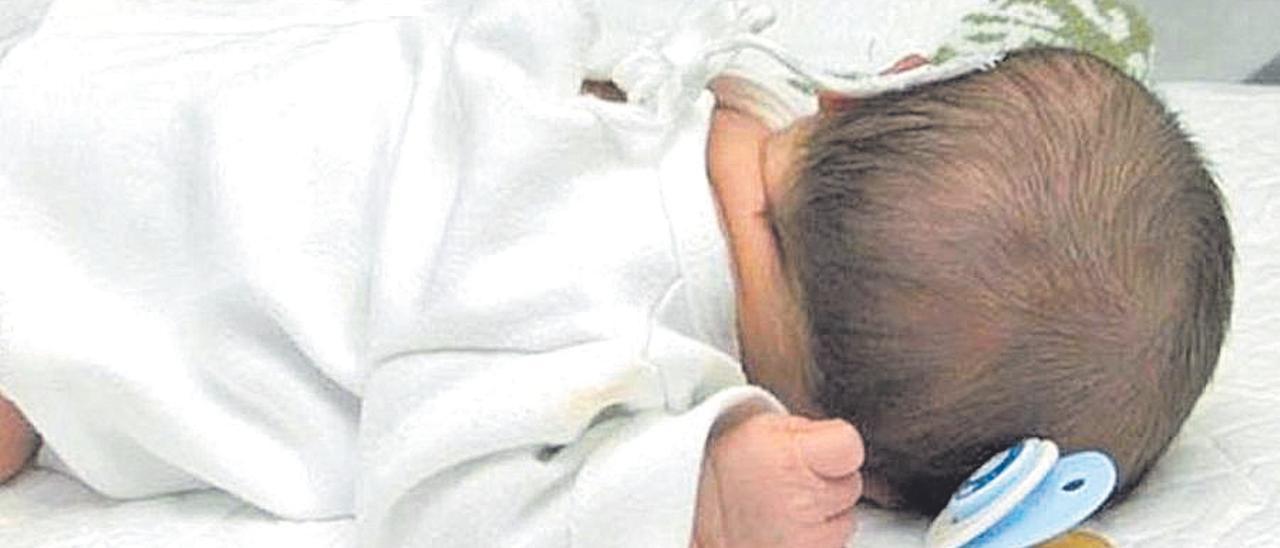 Un bebé duerme con su chupete.