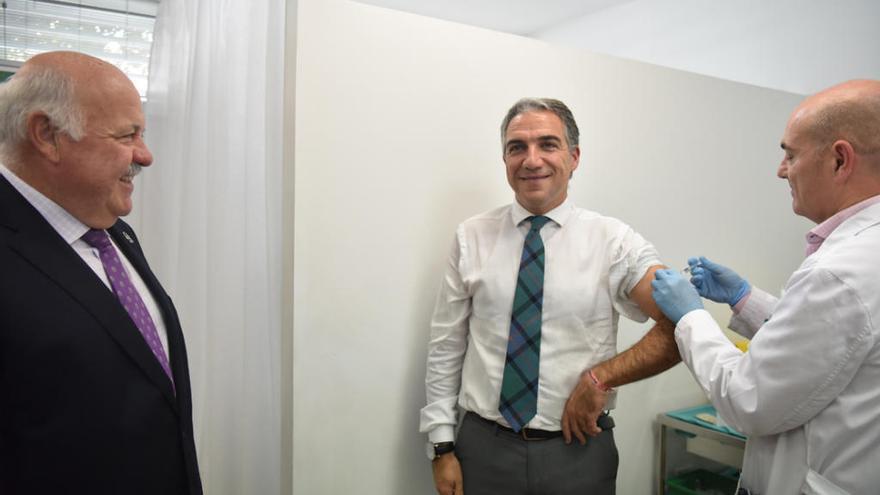 El consejero de Presidencia, Elías Bendodo (c), se vacuna contra la gripe, en presencia del consejero de  Salud y Familias, Jesús Aguirre (i)