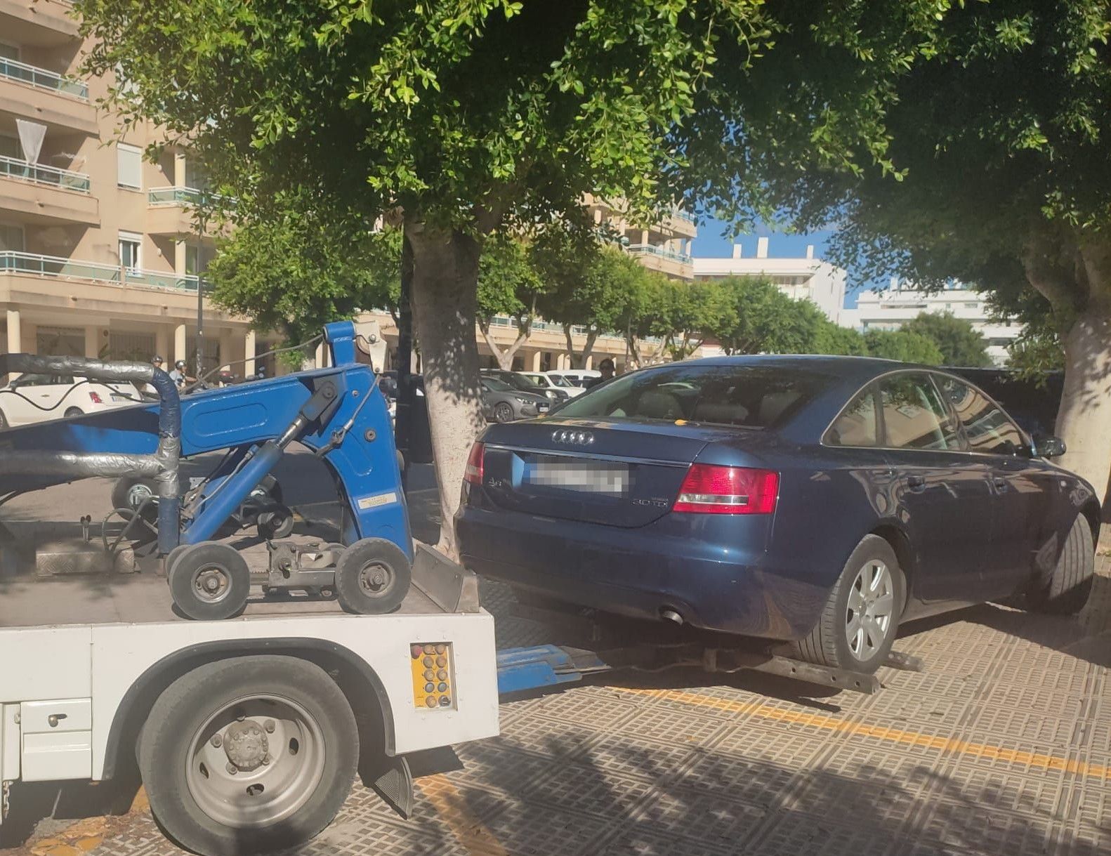 La grúa retira coches aparcados en al acera en Platja d'en Bossa