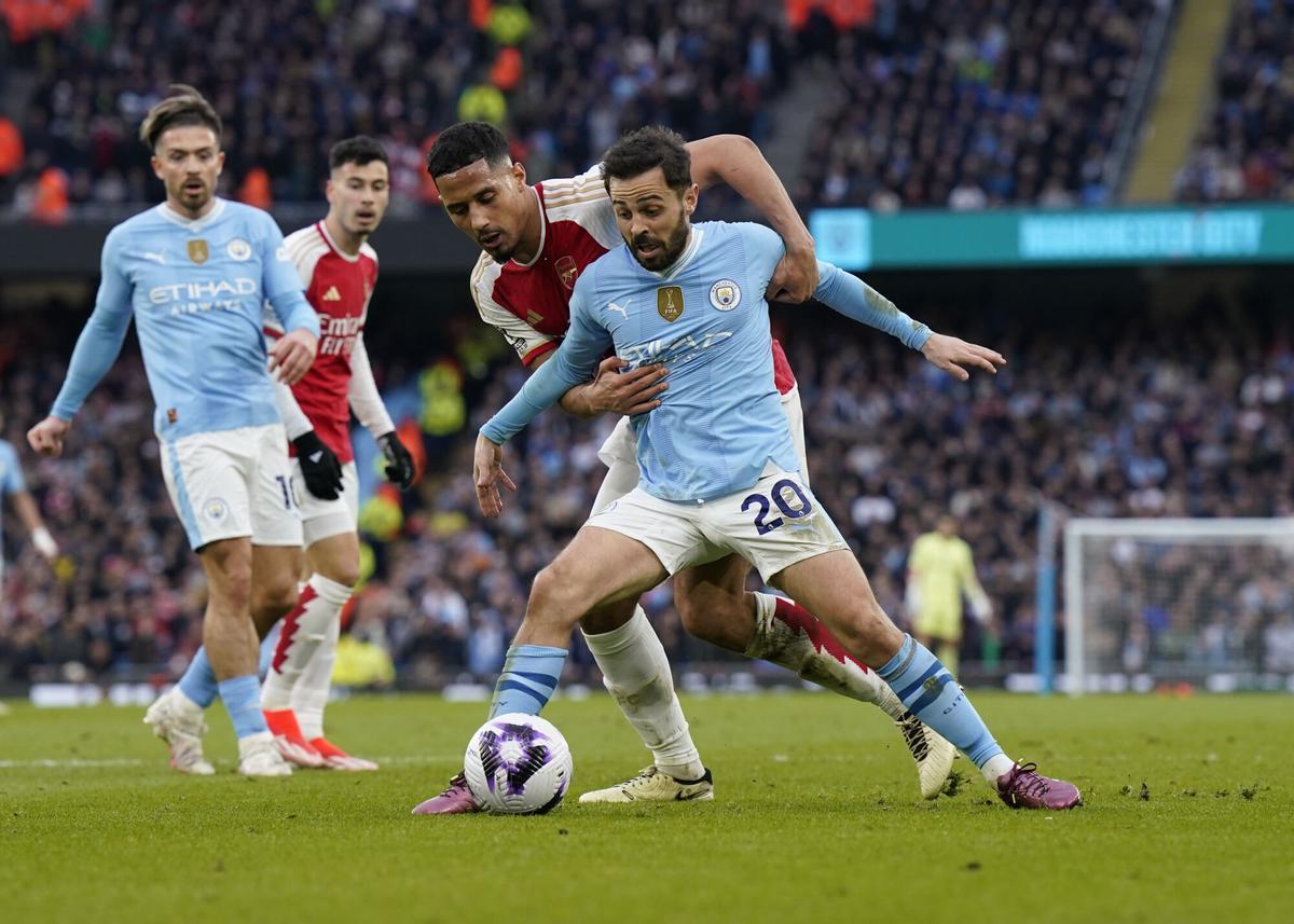 31 March 2024, United Kingdom, Manchester: Arsenal's William Saliba and Manchester City's Bernardo Silva (R) battle for the ball during the English Premier League soccer match between Manchester City and Arsenal at the Etihad Stadium. Photo: Andrew Yates/CSM via ZUMA Press Wire/dpa Andrew Yates/CSM via ZUMA Press / DPA 31/03/2024 ONLY FOR USE IN SPAIN. Andrew Yates/CSM via ZUMA Press / DPA;Sports;sports;soccer;football;England Premier League - Manchester City vs Arsenal;