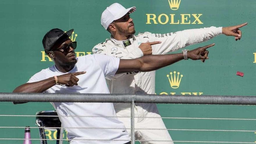 Hamilton celebra su victoria en el podio en compañía de Usain Bolt. // Efe