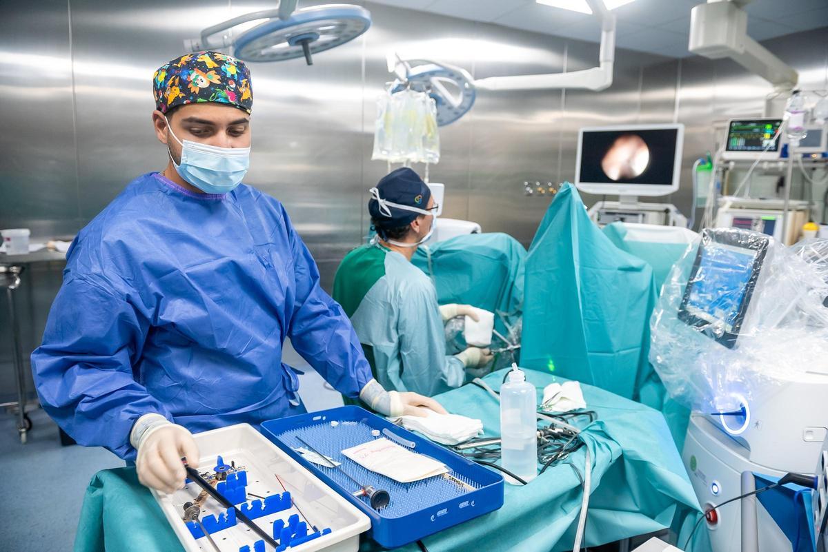 El Dr. Antonio Servera Ruiz de Velasco, al fondo, en plena intervención quirúrgica.