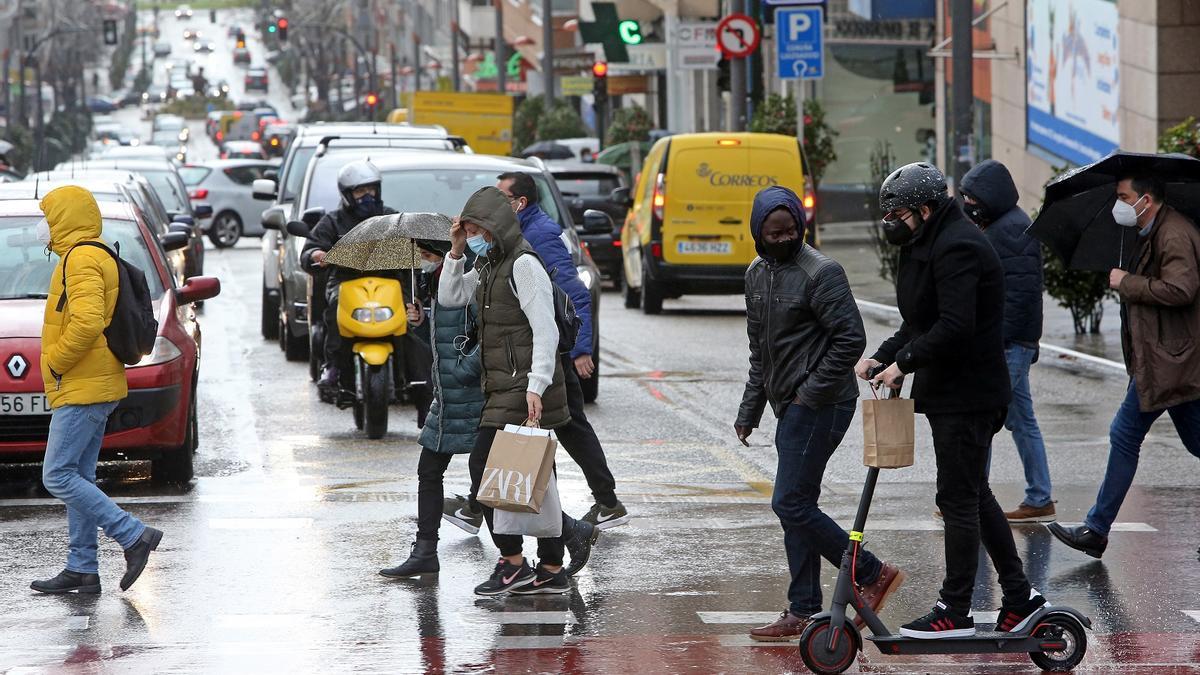 Gente pasea por el barrio de As Travesas, donde se ubica el apartamento