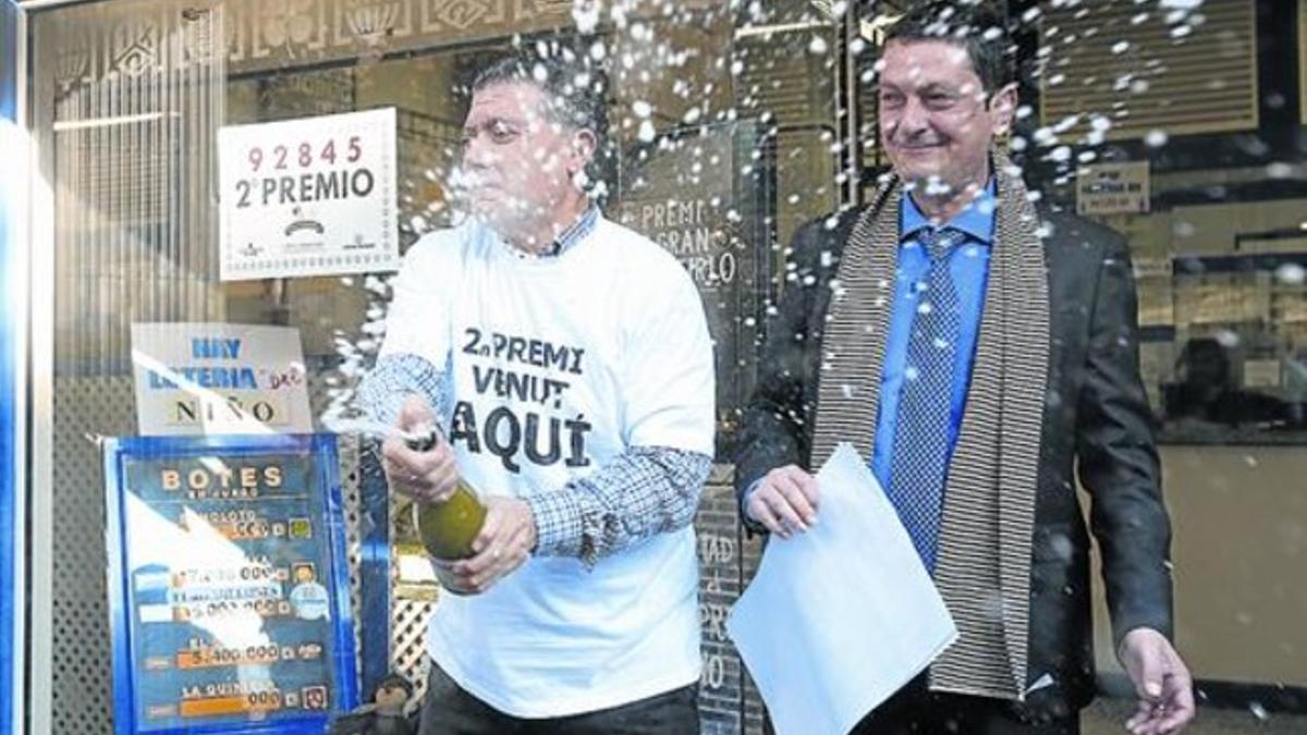 El lotero de la rambla de Just Oliveres descorcha una botella de cava.