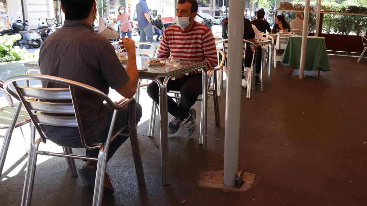 Un grup de persones assegudes a la terrassa d&#039;un bar.