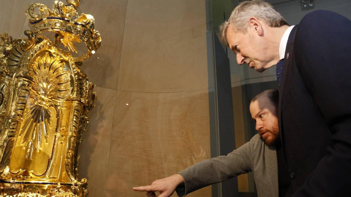 Una de las piezas de oro  de la muestra del Museo Centro Gaiás en Santiago, observada por el divulgador Miguel Cajigal y el presidente de la Xunta en funciones, Alfonso Rueda.