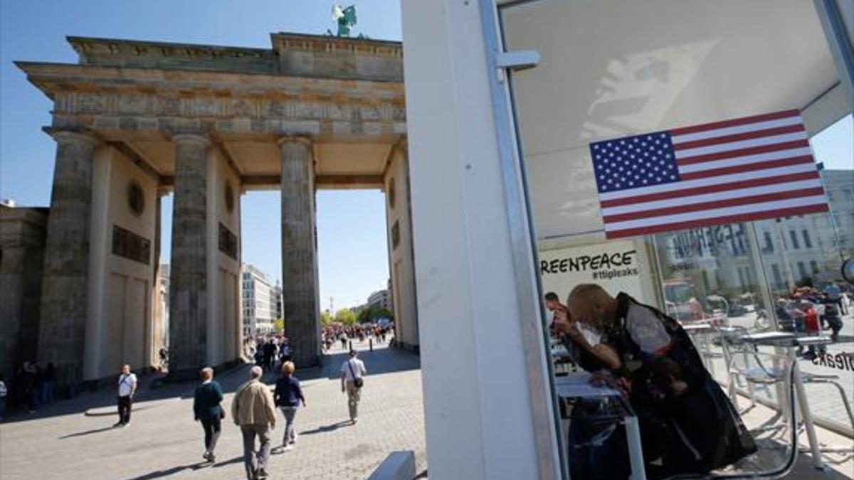 Ciudadanos consultan datos del TTIP, en una instalación de Greenpeace ante la puerta de Brandeburgo de Berlín, ayer.