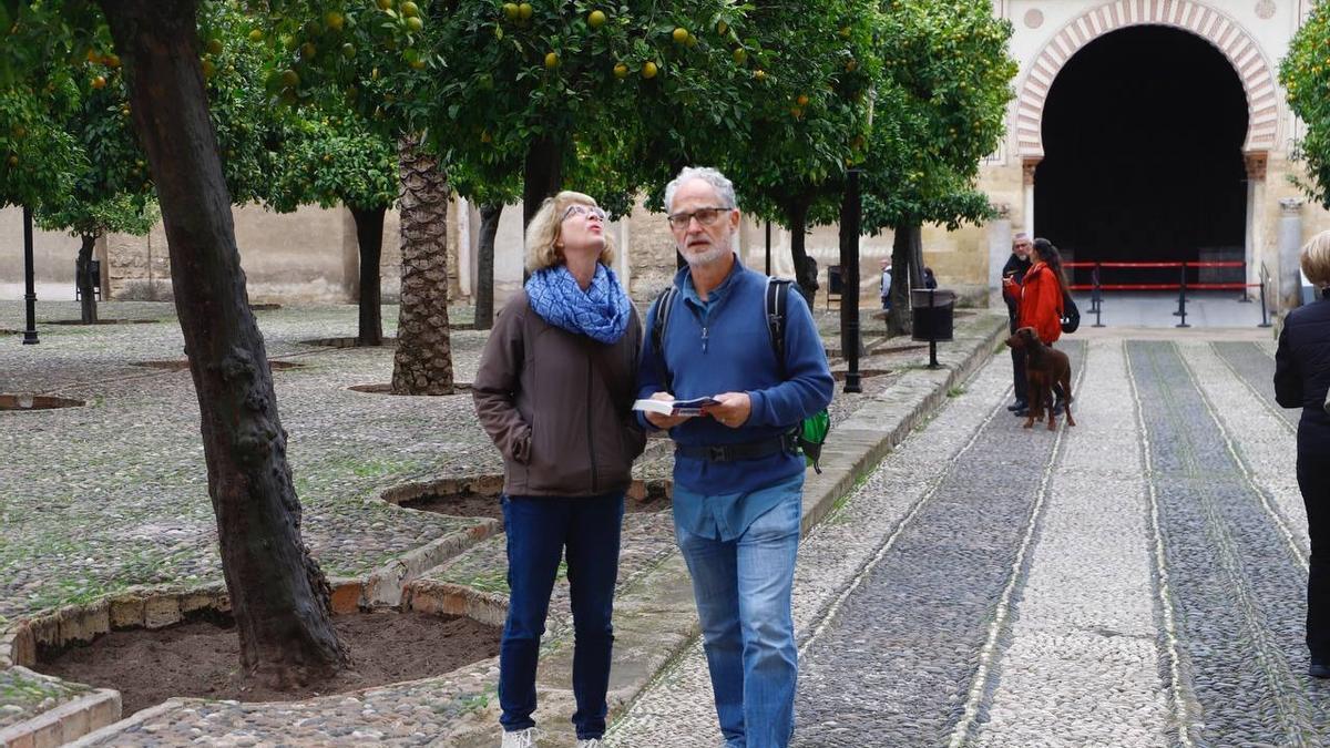 Dos turistas, en el Patio de los Naranjos de Córdoba.
