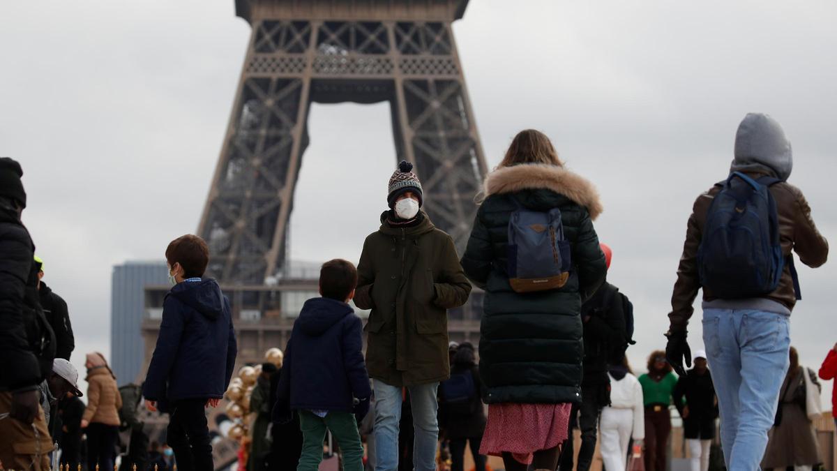 Ciudadanos franceses paseando al lado de la Torre Eiffel.