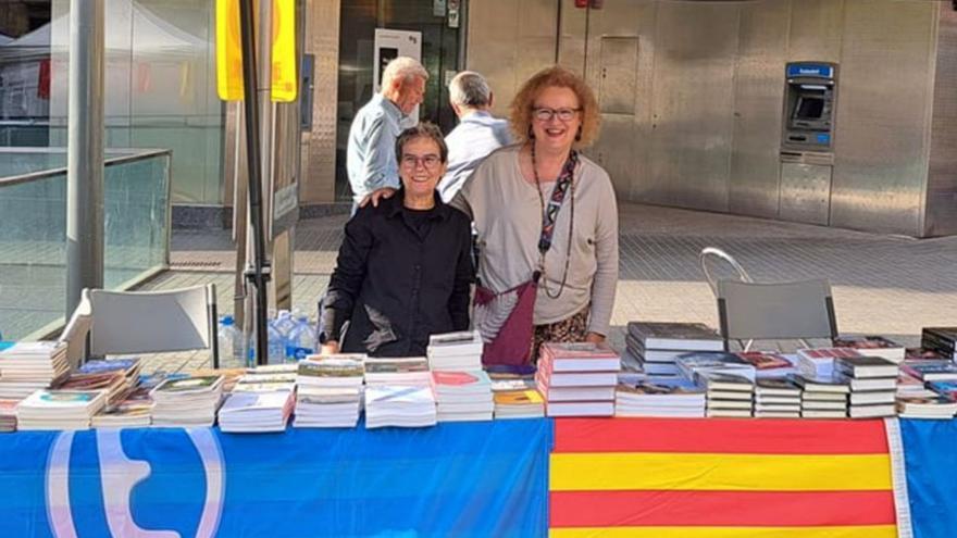 Esther Prieto (de Ediciones Trabe, a la izquierda) y Ana Roza (de Delallama), ayer, nada más abrir el puesto del Gremio de Editores de Asturias.