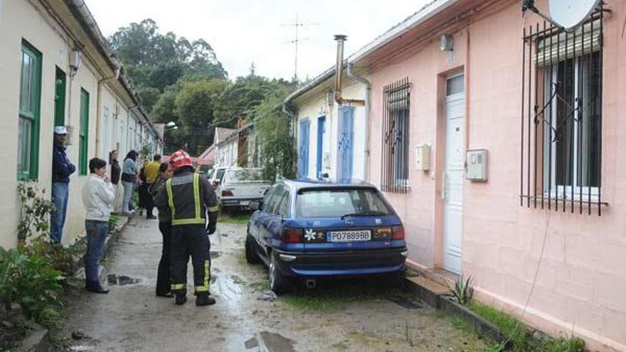 Los bomberos hablan con algunos vecinos ante la casa donde se produjo el incendio.  // Rafa Vázquez
