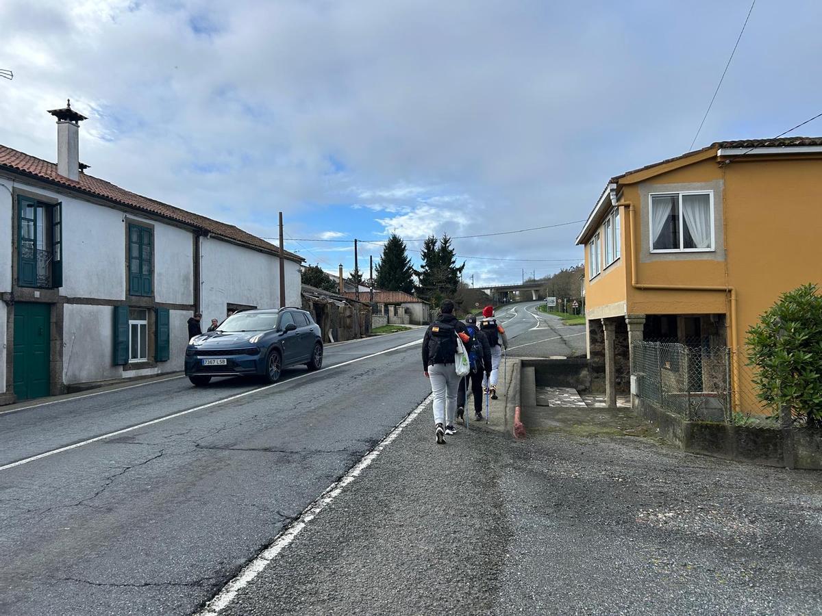 Peregrinos del Camino Inglés a su paso por A Sionlla de Abaixo, donde circulan por el arcén de la carretera N-550