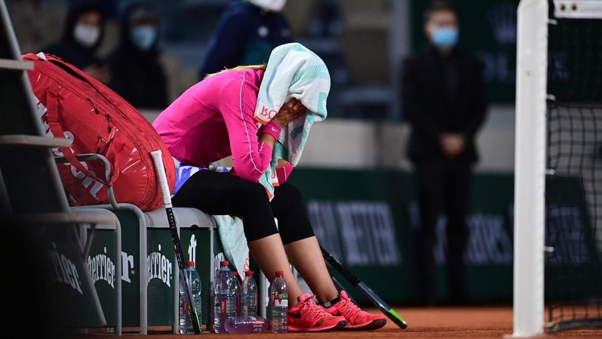 Paula Badosa llora bajo una toalla tras derrotar a Ostapenko en Roland Garros.