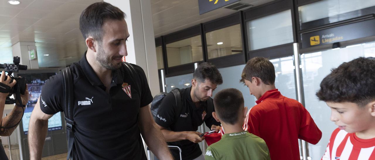 Cali Izquierdoz y Jony firman autógrafos a su llegada al aeropuerto con la expedición del Sporting