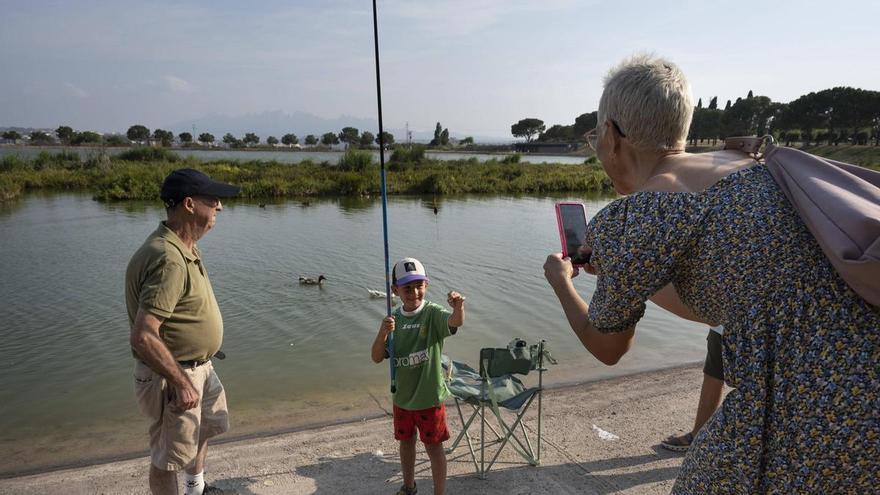 Un peix gat, un gardí, una carpa: infants aprenen a pescar al llac de l'Agulla