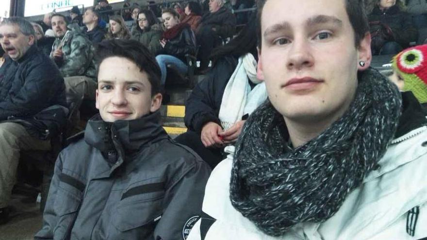 Jorge González Vega (derecha) junto a un joven canadiense viendo un partido de hockey.