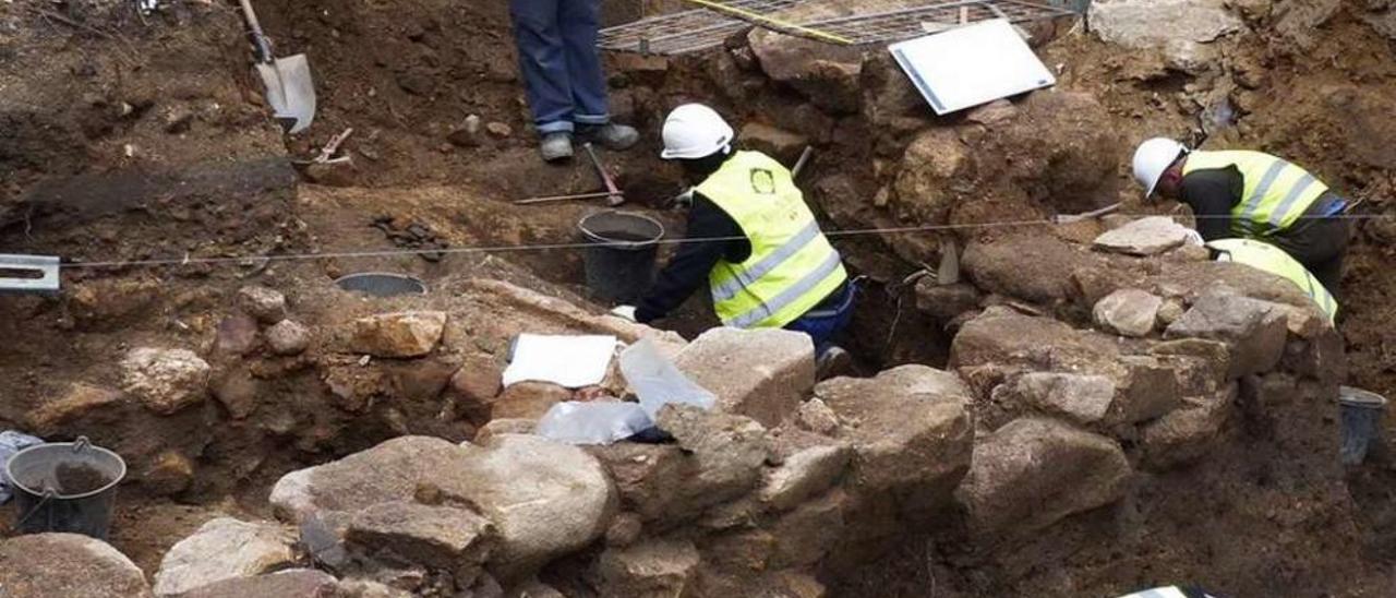 Un grupo de arqueólogos trabaja en las tumbas halladas en el solar del Casco Vello. // Anta de Moura