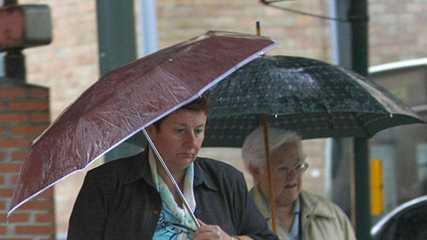 Dos mujeres pasean por Málaga en una jornada lluviosa.