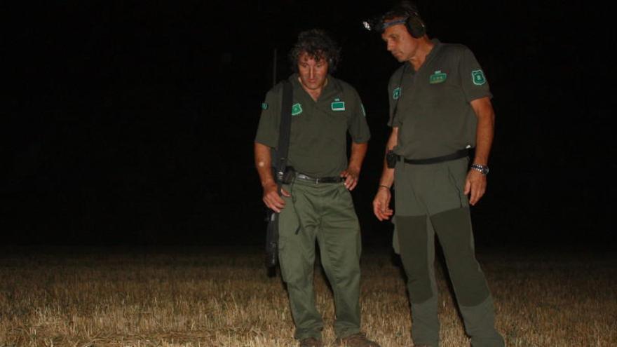 Dos agents rurals al costat d&#039;un senglar abatut des del tot terreny durant un recorregut nocturn a la zona de Cruïlles