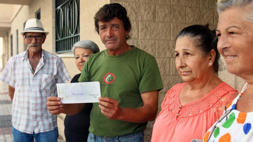 Paco Luque, con vecinos de García Grana en el bloque en el que vivía su madre y un recibo de alquiler de los años 90.