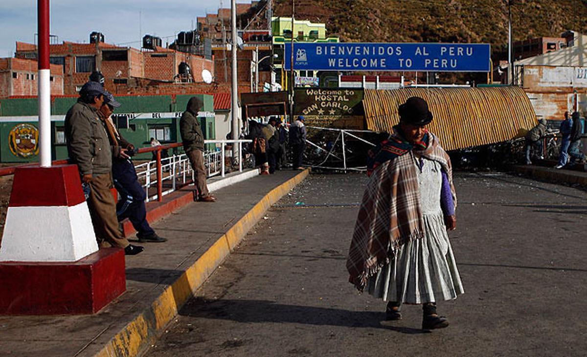 Una dona camina aquest dimarts per la població de Desaguadero (Bolívia) durant un bloqueig de l’autopista que uneix Bolívia amb el Perú en protesta per una concessió minera a la companyia canadenca Santa Ana, davant la por que pugui contaminar el llac Titicaca.