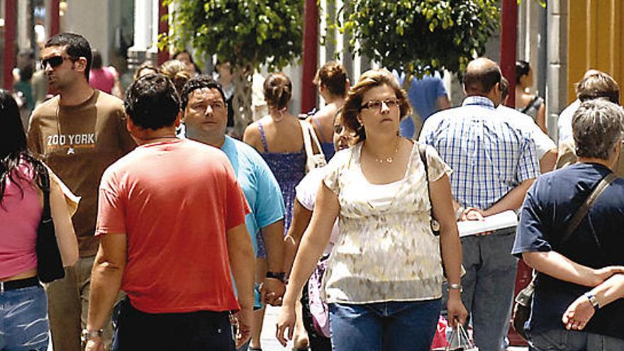 Varias personas caminan por la calle mayor de Triana.