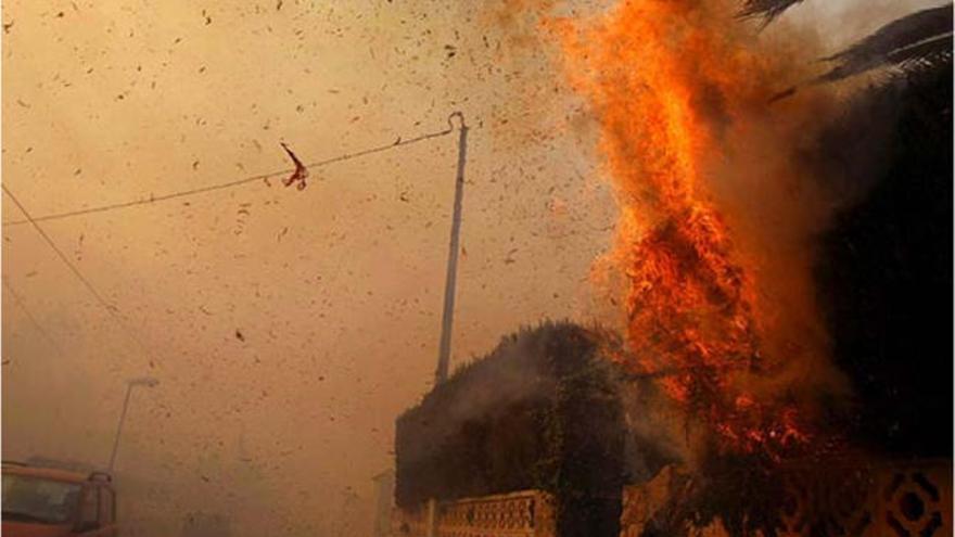 El fuego se propaga en una vivienda a través de los cipreses.