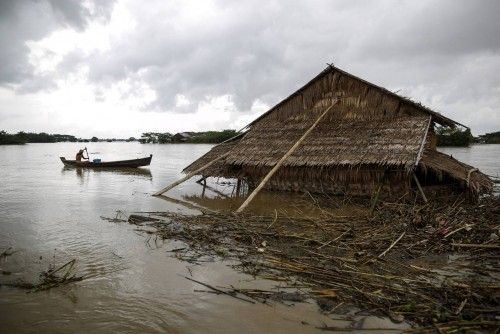A man rows his boat in a flooded village outside Zalun Township, Irrawaddy Delta