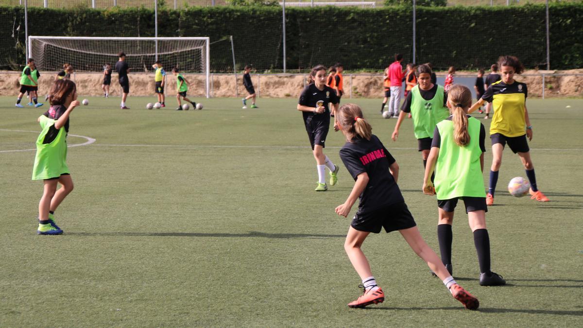 Les jugadores del Gerunda FC compartint el camp de Fontajau amb l'equip masculí Atlètic Sant Ponç al fons