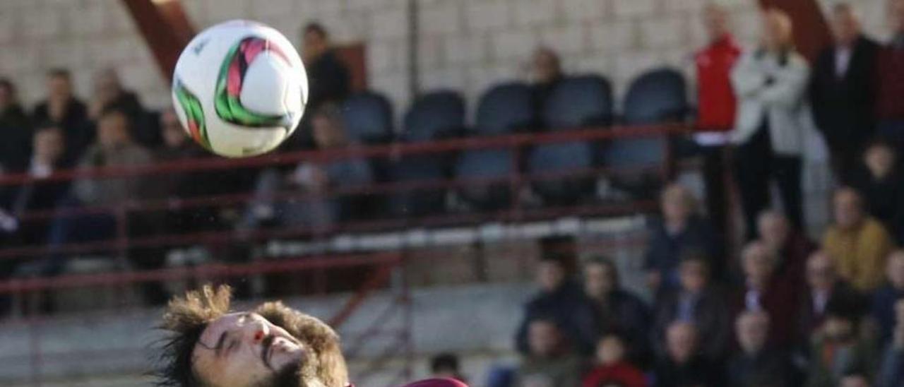 Pablo Carnero disputa un balón aéreo a un defensor rival. // J. Lores