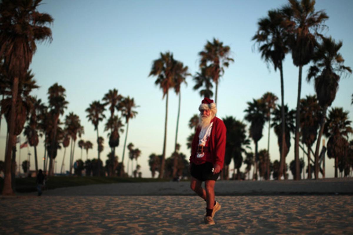 Un home vestit de Santa Claus passeja un dia d’Agost per la platja de Venice a Califòrnia (EUA).