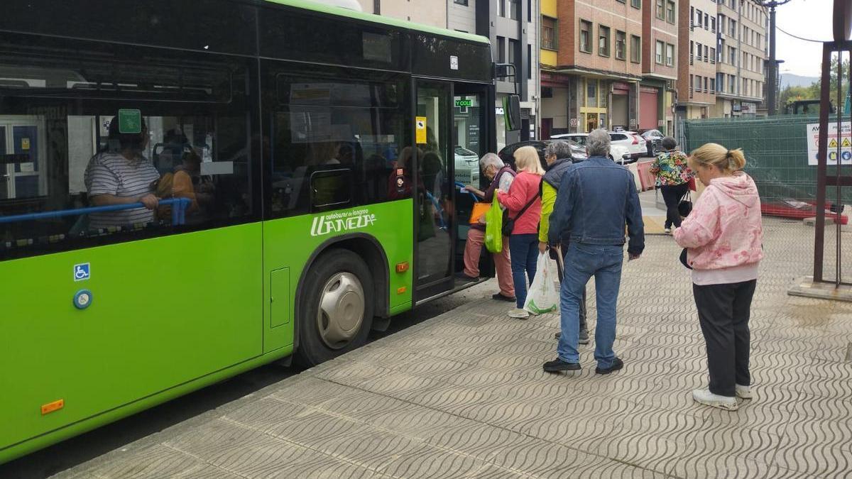 Usuarios subiendo al autobús en Sama.