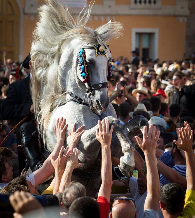 Un caballo se levanta entre la multitud durante el Caragol des Born, una misa de caballos y personas que se arremolinan al ritmo de la música durante el tradicional festival de Sant Joan (San Juan) en la ciudad de Ciutadella, en la isla de Menorca.