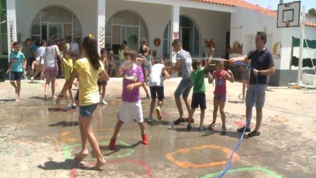 Alumnos de un colegio andaluz se refrescan con una manguera ante la ola de calor.