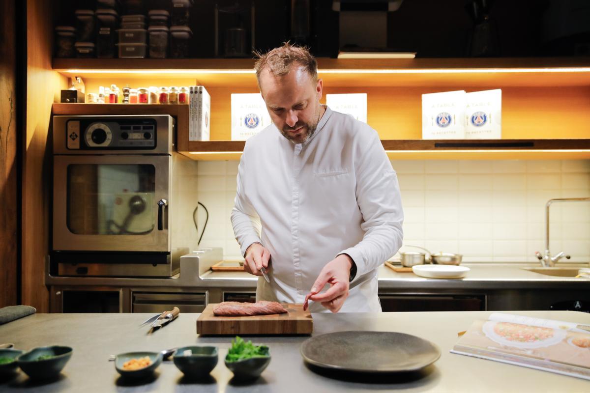 David Toutain cocina en su restaurante de París el carpacho de ternera con queso azul, plato favorito de Kylian Mbappé incluido en el libro de las recetas de los jugadores del PSG que ha publicado el chef.