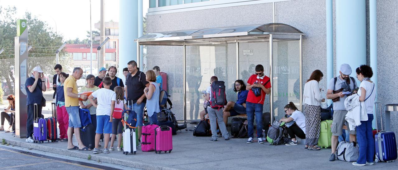 Turistas recién llegados en una marquesina del Aeropuerto de Vigo.