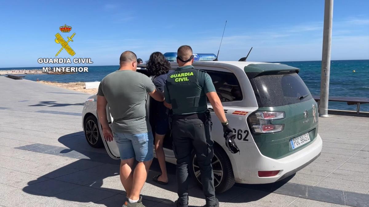 La Guardia Civil introduce en el coche patrulla a uno de los detenidos por la violación grupal en Torrevieja.