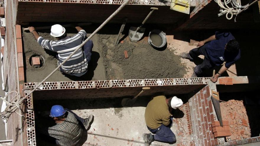 Cuatro obreros trabajan en la construcción de un edificio. // Fran Martínez