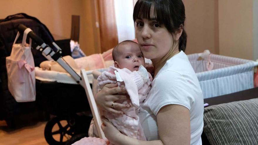 Sandra Pinilla, con la pequeña Julia en brazos, en su casa de Pola de Lena.