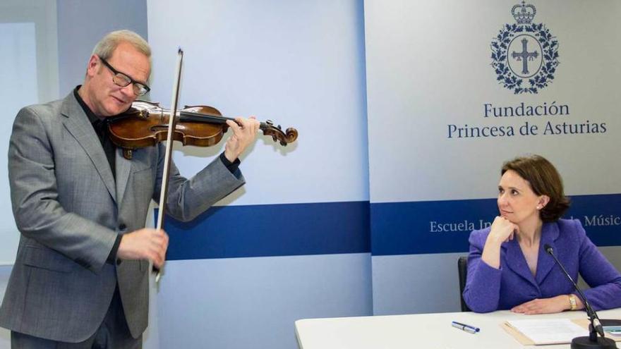 Yuri Nasushkin tocando el violín y Teresa Sanjurjo, ayer en la presentación de los cursos de verano.