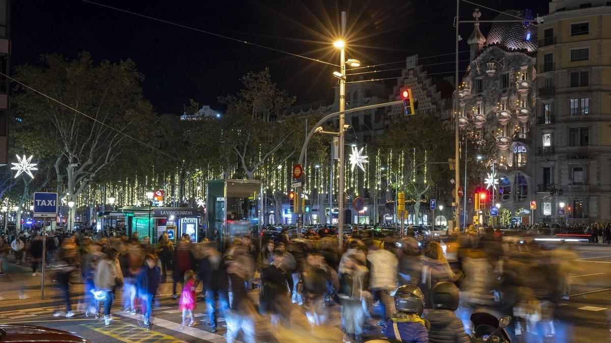 El centro de Barcelona abarrotado de gente bajo las luces de decoración de la Navidad.