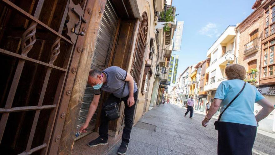 Un comerciante de Aranda de Duero cierra la persiana de su negocio.