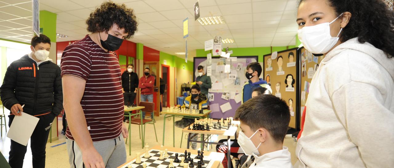 David Lariño (izqda.) jugando una de las partidas simultáneas en el IES Aller Ulloa