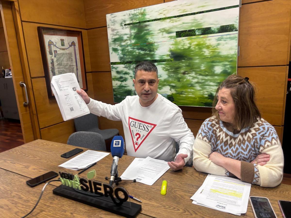 Javier Rodríguez muestra la factura de la discordia en presencia de la edil Sonia Lago.