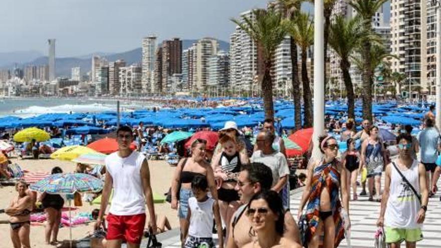 Turistas en la playa de Levante de Benidorm, cuyos hoteles han podido por fin subir sus precios este año.