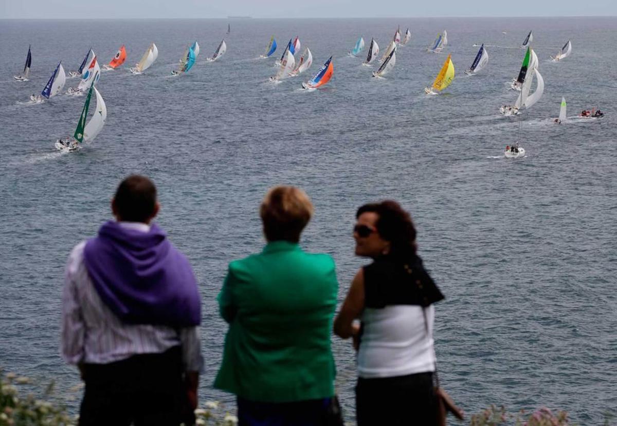 Tres personas observan la salida de "Le Figaro" de Gijón en la edición de 2013.