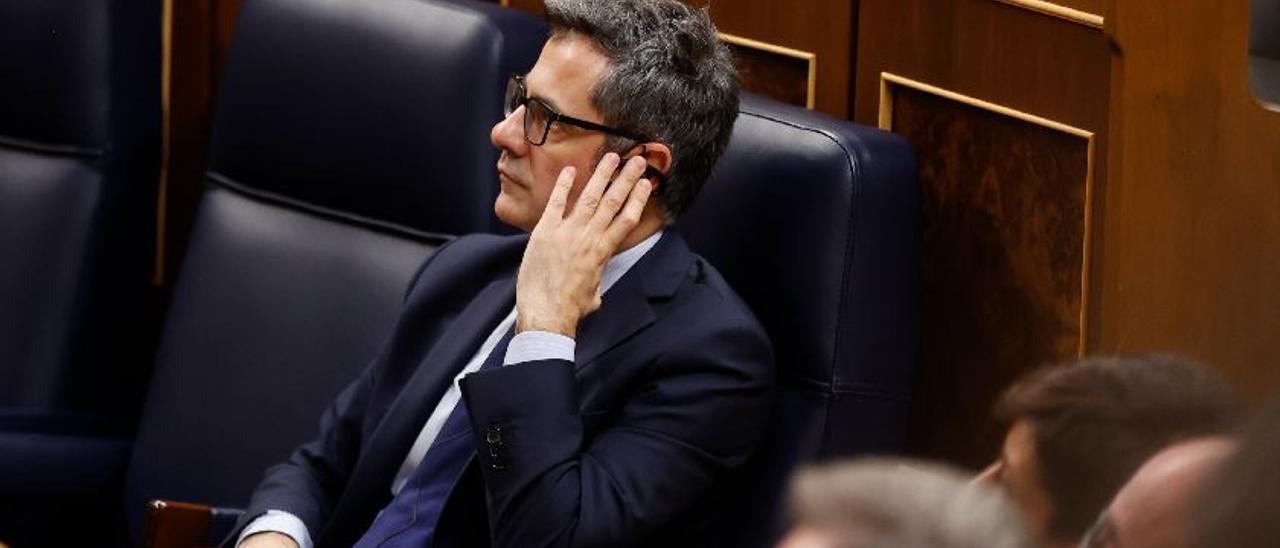 Minister Félix Bolaños lauscht im Parlament in Madrid einer Übersetzung.
