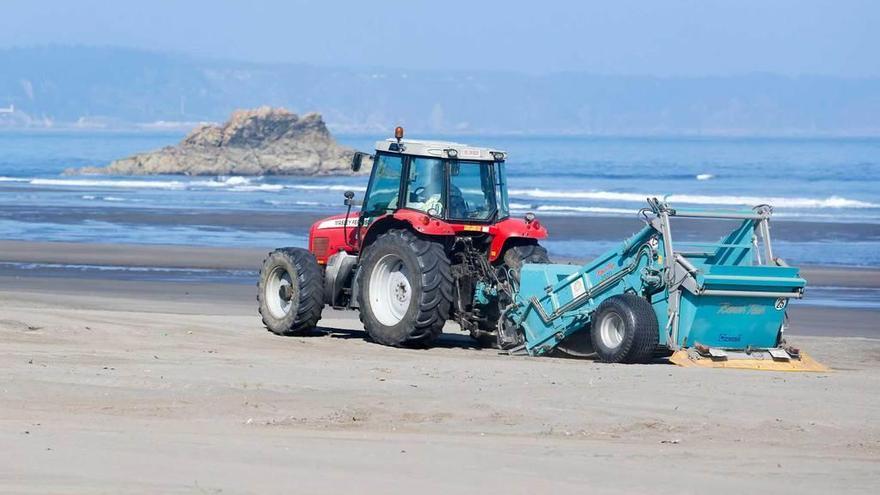 Una máquina, limpiando la playa de Bayas el verano pasado.