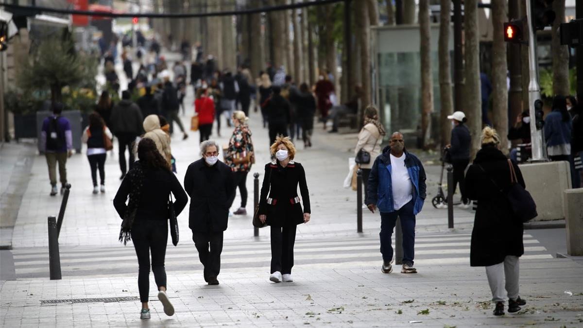 Gente caminando por los Campos Elíseos de París, este lunes, primer día de la desescalada.